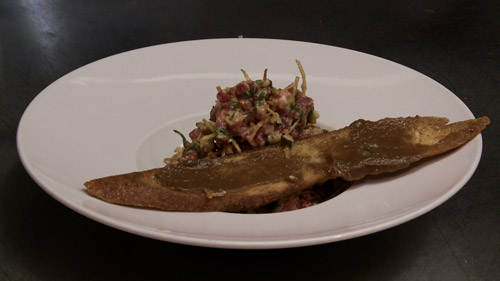 Tartare de bœuf, ail confit, chorizo, huile de truffe et pommes de terre allumettes