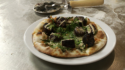 Pizza au boudin noir, oignons caramélisés, cheddar et épinards