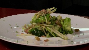Salade effeuillée de choux de Bruxelles aux raisins dorés et noix de pin